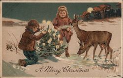 A Merry Christmas - children outside with small Christmas tree, deer standing close by Postcard