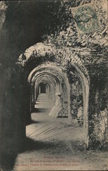 Woman seated in an abbey corridor Postcard