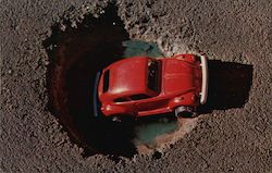 Red toy VW Bug in a pothole Postcard