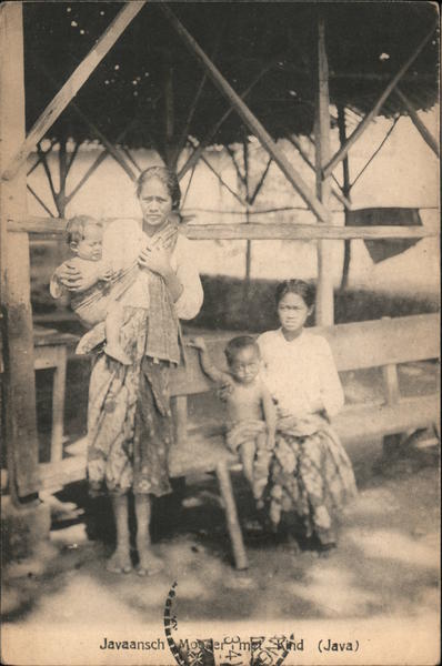 Two women wearing blouses and sarongs with their children Java