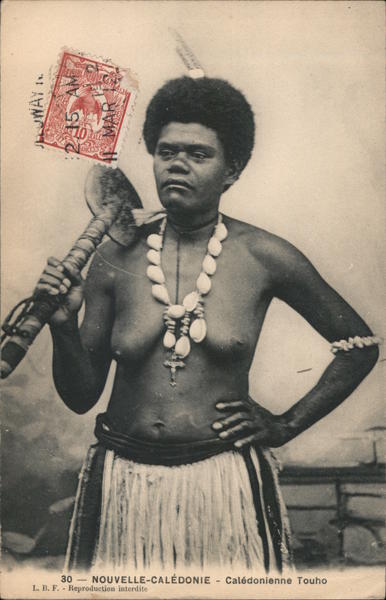A Pacific Islander woman wearing a shell necklace and grass skirt holding a cudgel Touho New Caledonia