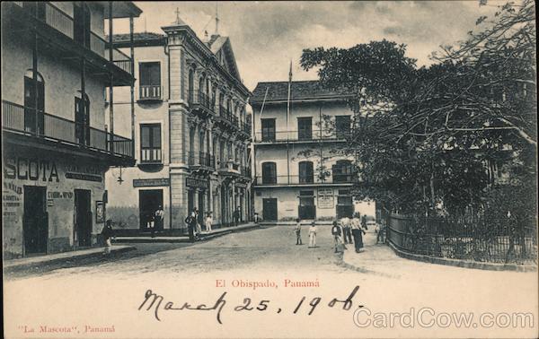 A street with three story buildings and a park with pedestrians El Obispado Panama