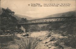 Train bridge crossing a river between the mountains Postcard