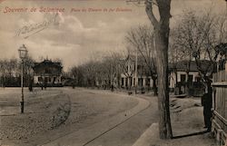 Small railway tracks along a street lined with houses and trees Postcard