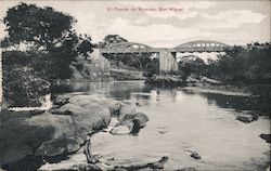 Photograph of a river with a bridge in the background Postcard