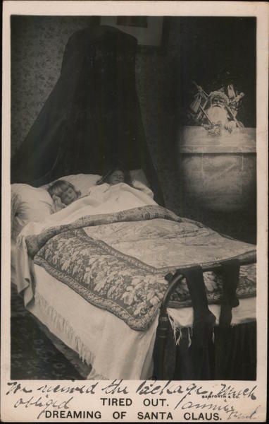 Tired Out. Dreaming of Santa Claus - 2 Little Girls Sleeping in Bed Dreaming of Santa