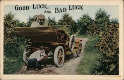 Good luck and bad luck A couple kissing in the back of open motorcar while boy fixes tire Couples Postcard Postcard Postcard