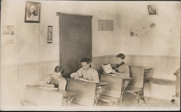 Three children at school desks in classroom Kowanda Nebraska