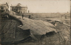 After tanks burst, men standing on remains, probably Nebraska Postcard