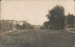 Main Street View, dirt road and horse drawn wagons Postcard