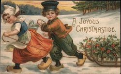 A joyous Christmastide - Dutch boy & girl pulling sled with holly on it Postcard