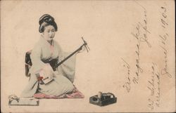 A Japanese lady playing a Shamisen Postcard