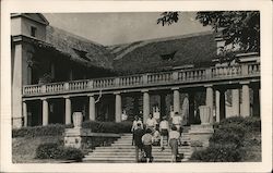 Group of people, steps, tile roofed building Postcard