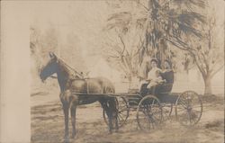 Two women and child in horse-drawn open buggy Postcard