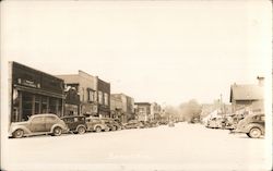 Main Street view, LGA Stores, business district, cars Postcard