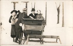 Couple in sleigh and with another couple standing nearby Postcard