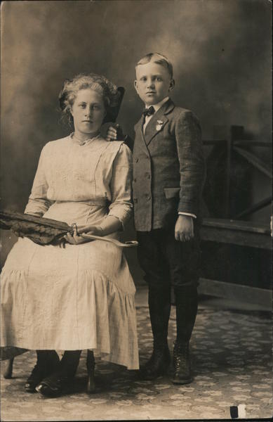 Professionally taken photo of 2 children in formal dress, circa 1900.