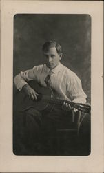 Seated Man in Striped Shirt Playing Guitar Postcard