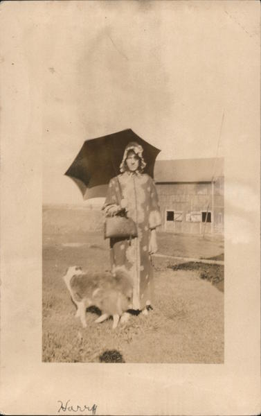 Woman in Housecoat, Ruffled Bonnet, Umbrella with Dog in Front of a Barn
