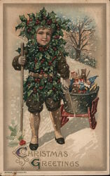 "Christmas Greetings" - a boy wrapped in holly pulling a sled of toys in the falling snow Postcard