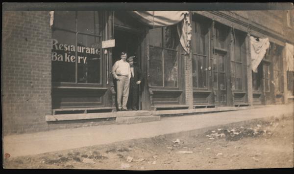 Two Men Stand in Front of Restaurant Bakery Occupational