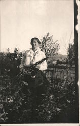 Woman Standing Among the Rosebushes with Saxophone Postcard