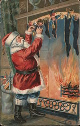 A Merry Christmas Santa filling stockings hung by the fireplace. Postcard