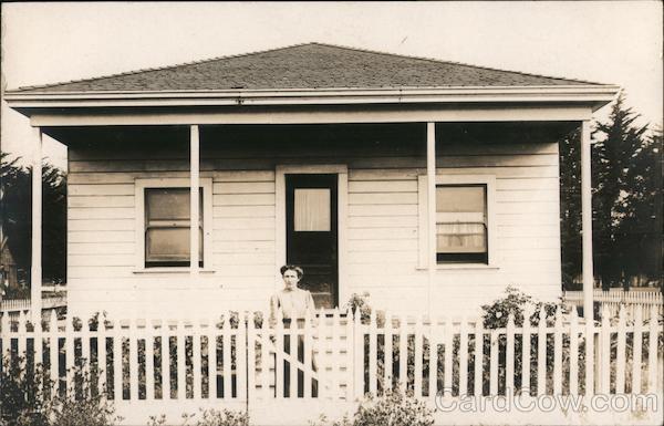 Fitchburg, Woman Standing in Front of House with White Picket Fence Oakland California