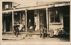 Adults and Children on Store Porch Postcard
