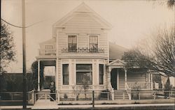 Woman Standing in Front of a Two Story House Postcard