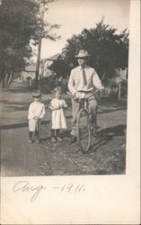 Man on Bicycle Next to Two Small Children Postcard