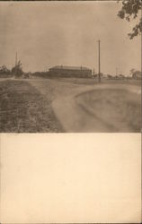 A Dirt Road with a Building in the Distance Postcard