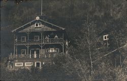 Three story lodge house in the woods with balconies Postcard