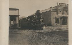 A Train Going Between Two Buildings Postcard