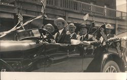 Men driving new car in Parade US Flags, Overland banners Postcard