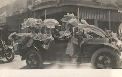 Women with parasols in open car decorated with bunting and US Flag Postcard