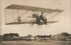 John and Laura Offley in plane flying over beach Postcard