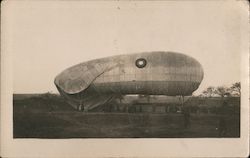 Blimp in field with people holding ropes Airships Postcard Postcard Postcard