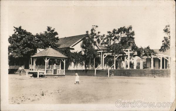 Young girl by pavilion in walled courtyard Coarsegold California