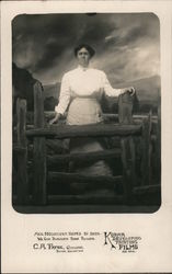 Studio Photograph of Woman standing behind fence with backdrop of storm on mountain Postcard