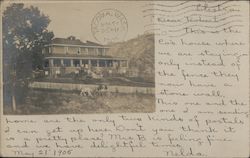 Large house on a hill with horse drawn carriage traveling up hill Postcard