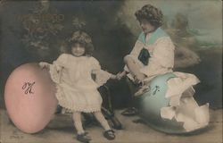 Girl with large pink egg and Boy with large hatched blue egg. Studio picture Postcard