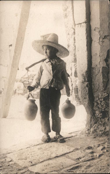 Mexican boy with water jugs Mexico