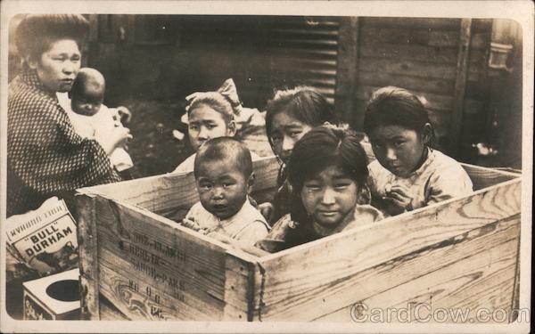 Asian woman with child, four children in crate
