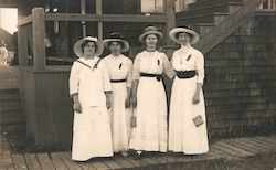 Four women in white with ribbon pins on blouses on a boardwalk Postcard