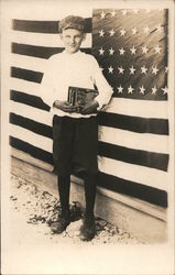 Patriotic: Boy with books standing next to U.S. Flag Postcard