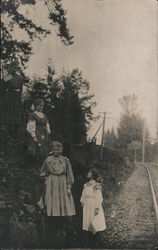 Four young girls with U.S. Flags standing by railroad tracks Postcard