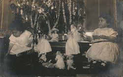 Small Girls and Dolls in front of Christmas Tree Postcard