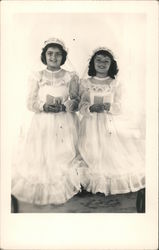 First communion for two young girls dressed in white, rosary and book Postcard