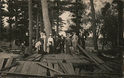 Group gathered on destroyed deck in forest Postcard